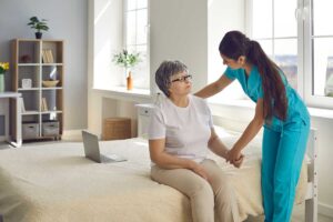 An older adult unpacks belongings in a cozy private room, arranging photos and a favorite blanket.